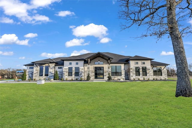 prairie-style house featuring stucco siding, stone siding, and a front yard