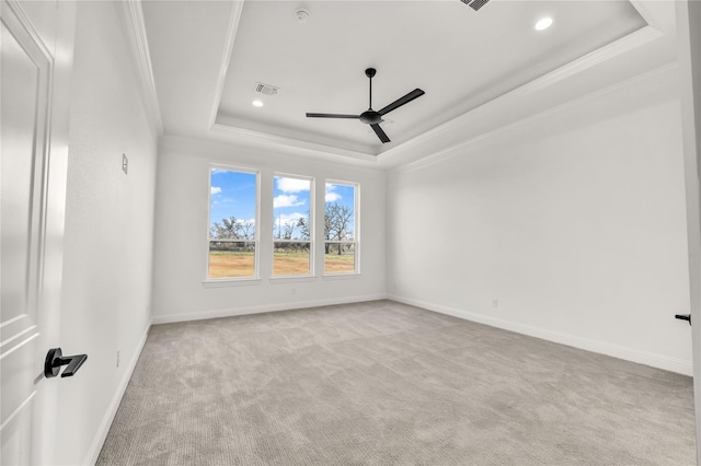 unfurnished room with carpet floors, a ceiling fan, visible vents, baseboards, and a raised ceiling