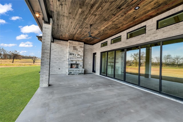 view of patio with an outdoor stone fireplace and a ceiling fan