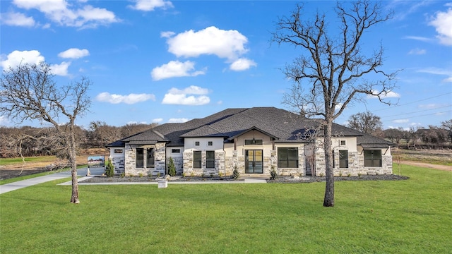 french country home with stone siding, a front lawn, and a shingled roof