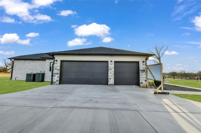 view of front of house with concrete driveway, central AC unit, an attached garage, and a front yard