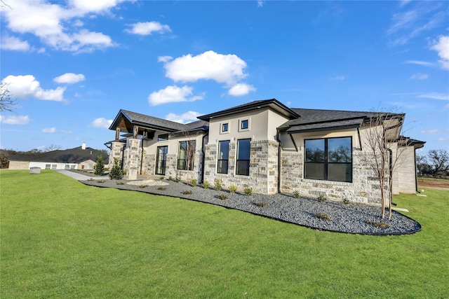 rear view of property with stucco siding, stone siding, and a yard