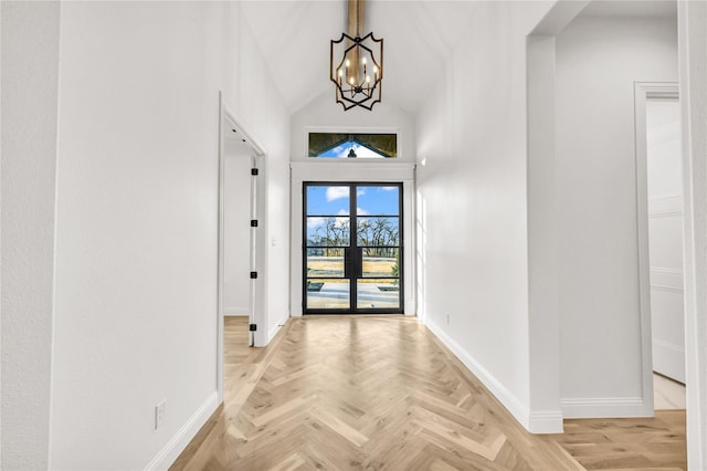 foyer featuring a chandelier, high vaulted ceiling, and baseboards