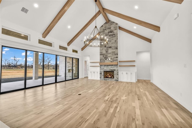 unfurnished living room featuring high vaulted ceiling, light wood-style floors, a stone fireplace, a chandelier, and beamed ceiling