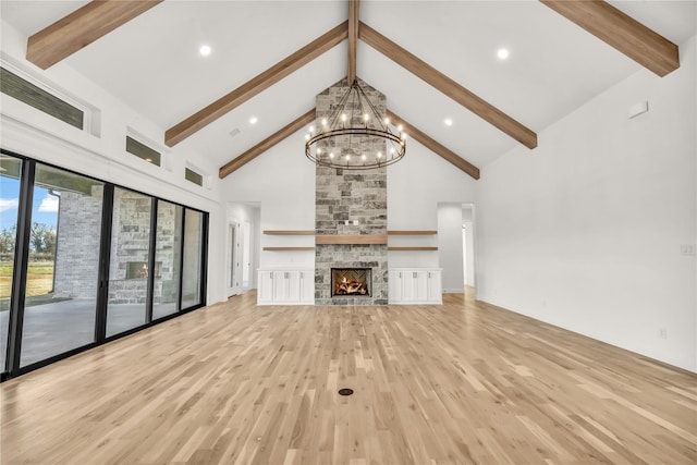 unfurnished living room with light wood finished floors, visible vents, a stone fireplace, high vaulted ceiling, and beamed ceiling