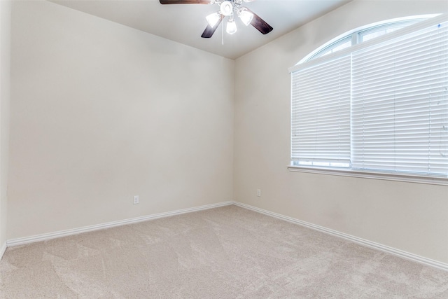 unfurnished room featuring light carpet, ceiling fan, and baseboards