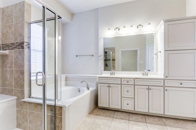 full bath with tile patterned flooring, a sink, a bath, double vanity, and a stall shower