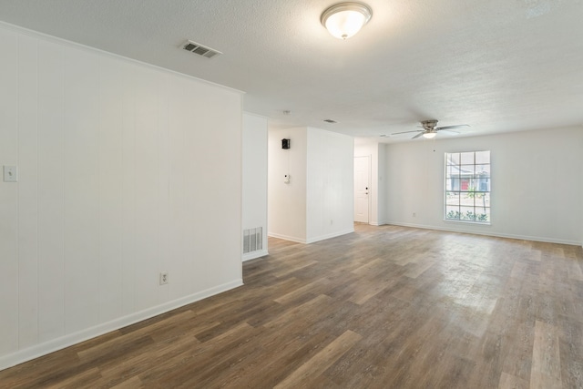 empty room with a textured ceiling, wood finished floors, visible vents, and a ceiling fan