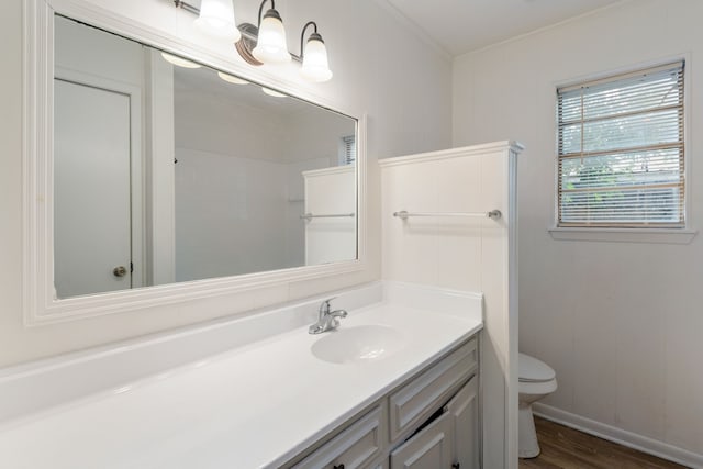 bathroom featuring crown molding, vanity, toilet, and wood finished floors