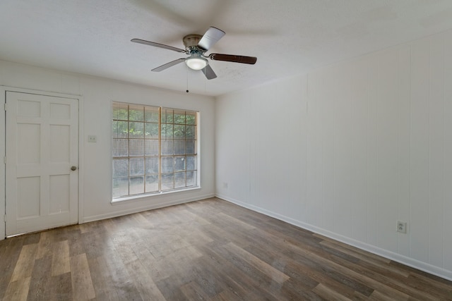 unfurnished room featuring dark wood-style floors, baseboards, a ceiling fan, and a textured ceiling