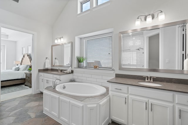 full bath with lofted ceiling, ensuite bath, a sink, and a garden tub