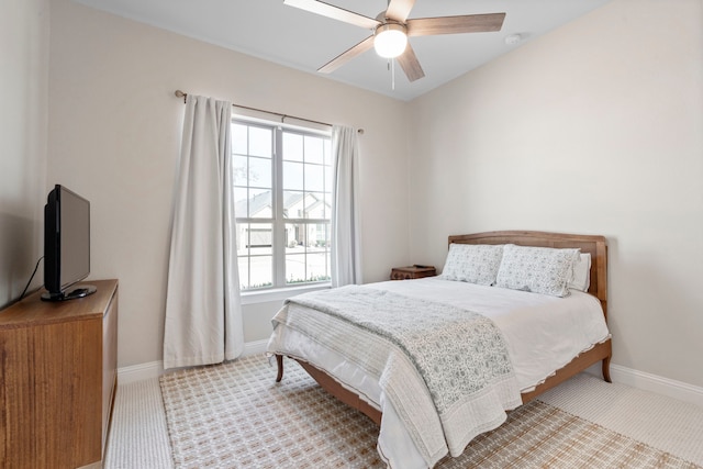 carpeted bedroom with ceiling fan and baseboards