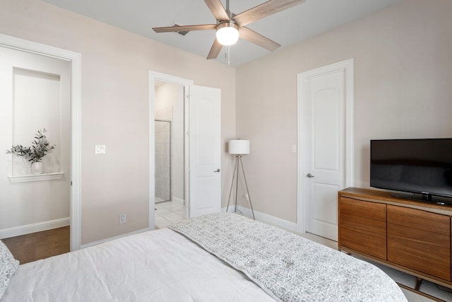 bedroom featuring a ceiling fan, connected bathroom, and baseboards