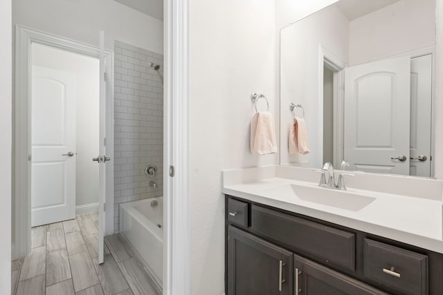 full bath with  shower combination, wood finish floors, and vanity