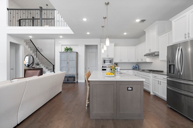 kitchen featuring white cabinets, appliances with stainless steel finishes, and open floor plan