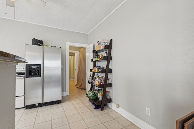 kitchen with lofted ceiling, a textured ceiling, light tile patterned flooring, white electric range, and stainless steel fridge