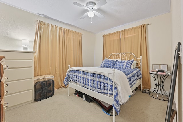 bedroom with crown molding, a textured ceiling, a ceiling fan, and carpet flooring