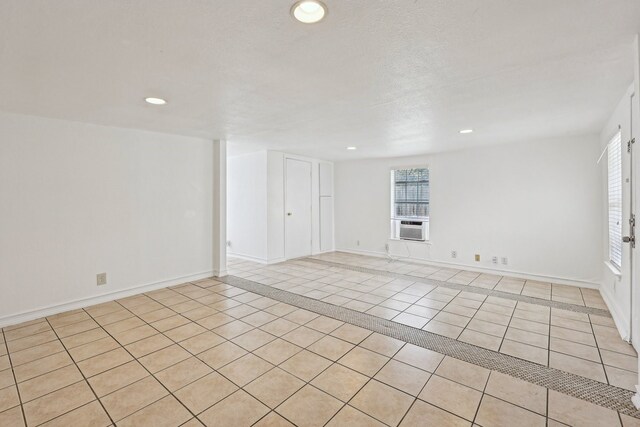 spare room with baseboards, light tile patterned flooring, cooling unit, and recessed lighting