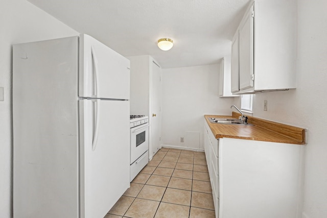 kitchen with white appliances, light tile patterned floors, light countertops, white cabinetry, and a sink