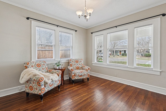 sitting room with baseboards, a textured ceiling, wood-type flooring, and an inviting chandelier