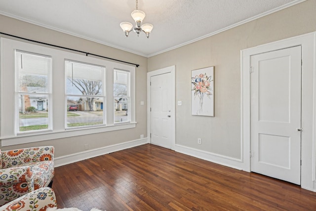 unfurnished room featuring baseboards, ornamental molding, hardwood / wood-style flooring, and a notable chandelier