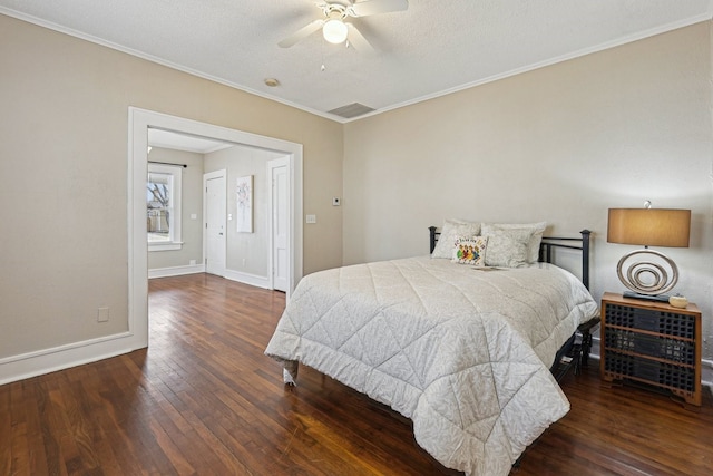 bedroom with visible vents, hardwood / wood-style floors, ornamental molding, ceiling fan, and baseboards