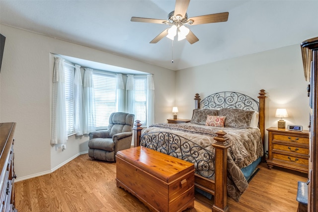 bedroom with light wood-type flooring, baseboards, and a ceiling fan