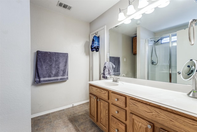 bathroom with a stall shower, baseboards, visible vents, tile patterned flooring, and vanity