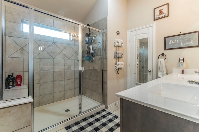 bathroom with double vanity, tile patterned floors, a sink, and a shower stall