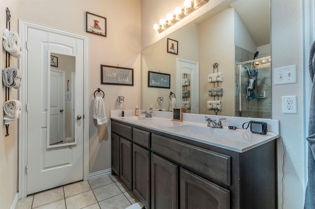 bathroom featuring double vanity, a shower stall, a sink, and tile patterned floors