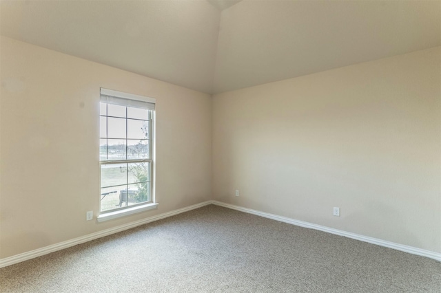 spare room featuring lofted ceiling, baseboards, and carpet flooring