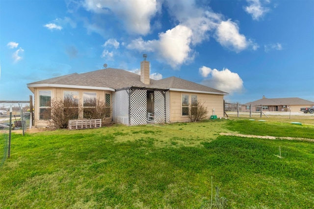 rear view of property with fence and a lawn