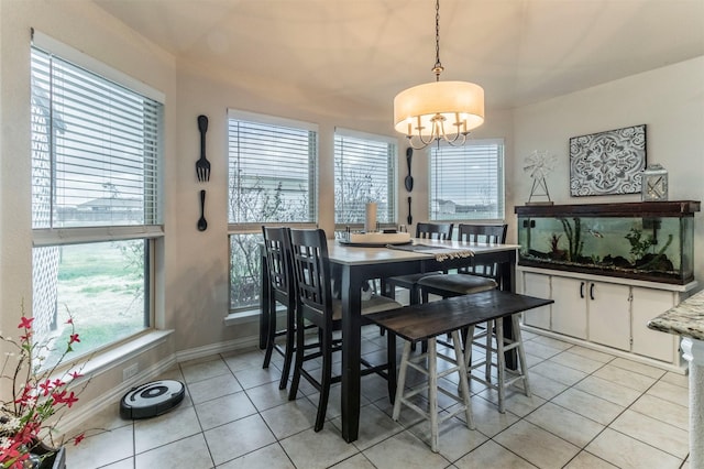 dining room with light tile patterned floors, plenty of natural light, baseboards, and a notable chandelier