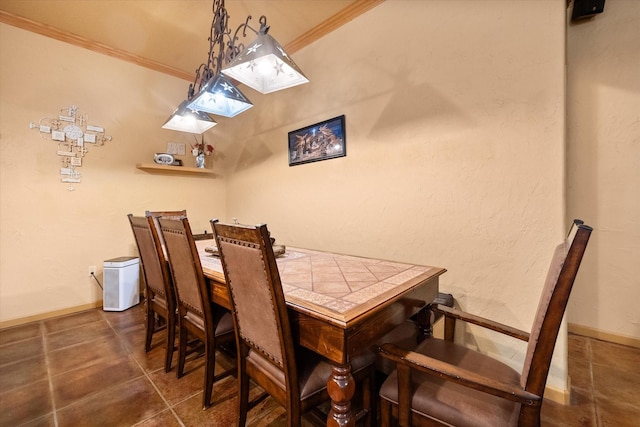 dining area featuring baseboards, tile patterned floors, and crown molding