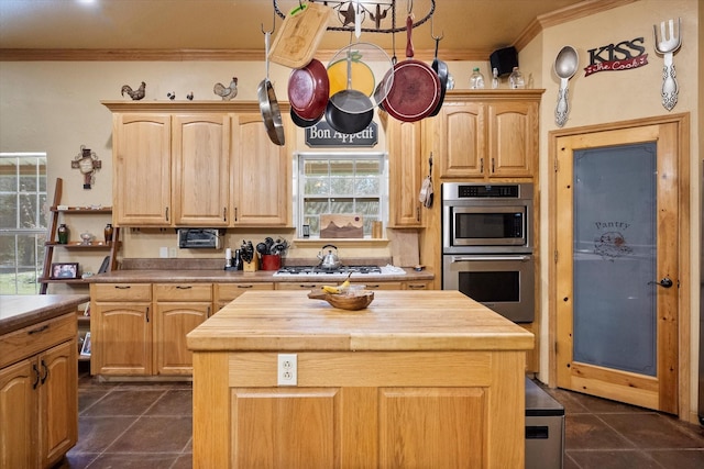 kitchen featuring ornamental molding, a center island, wooden counters, and light brown cabinetry