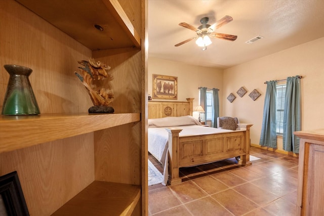 bedroom featuring a ceiling fan, visible vents, and tile patterned floors