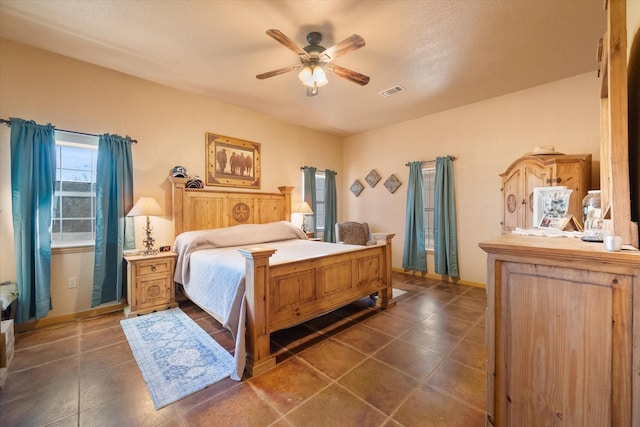 bedroom featuring tile patterned flooring, visible vents, and ceiling fan