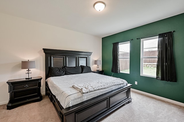 bedroom featuring light carpet and baseboards