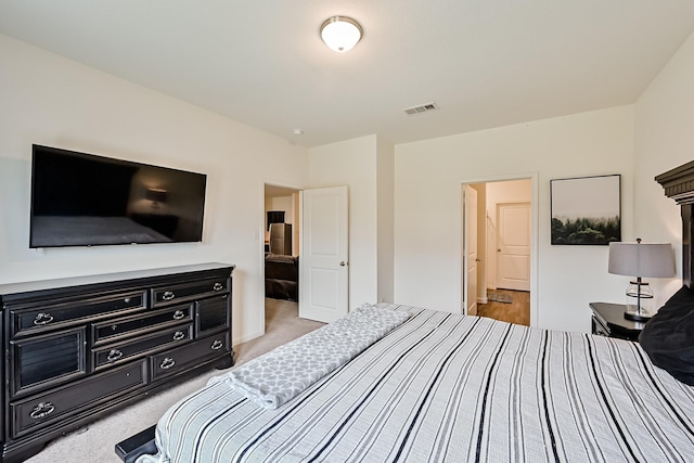 bedroom with visible vents and light colored carpet