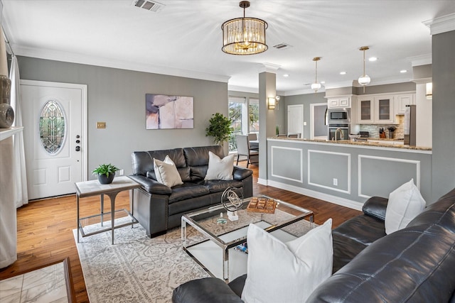 living room featuring crown molding, recessed lighting, wood finished floors, and visible vents