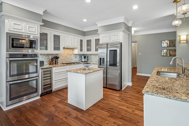 kitchen featuring a sink, a kitchen island, wine cooler, appliances with stainless steel finishes, and white cabinets