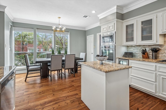 kitchen featuring dark wood-style floors, visible vents, stainless steel appliances, decorative backsplash, and white cabinets