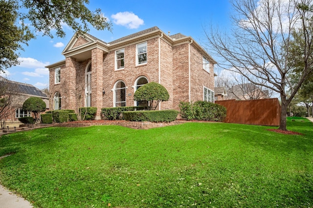 view of front of house featuring a front yard and brick siding