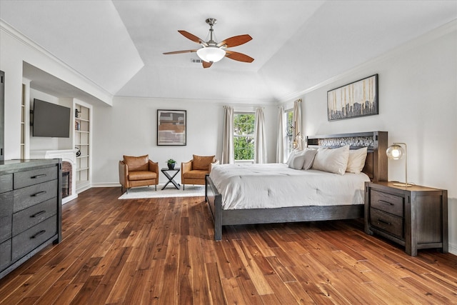 bedroom with a raised ceiling, crown molding, wood-type flooring, and ceiling fan