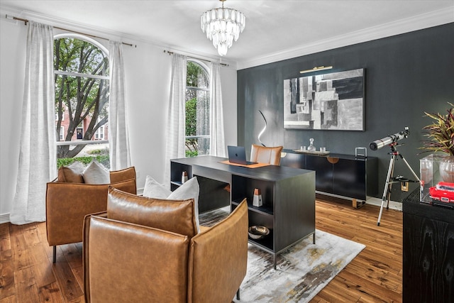 office space with crown molding, a notable chandelier, baseboards, and wood-type flooring