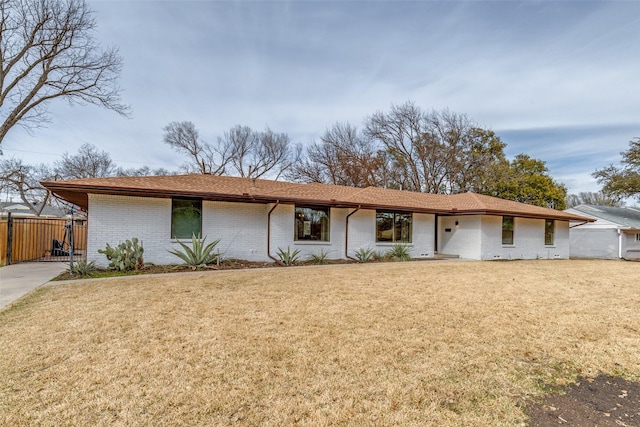 ranch-style house featuring brick siding and a front yard