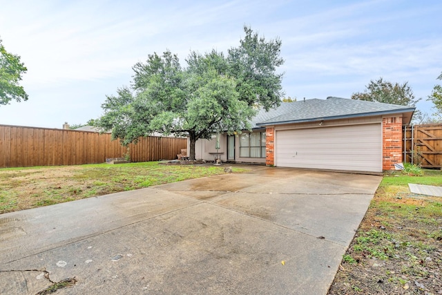 view of front facade featuring a garage, concrete driveway, fence, a front lawn, and brick siding