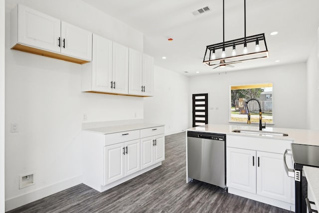 kitchen with dark wood-type flooring, stainless steel appliances, light countertops, white cabinetry, and a sink