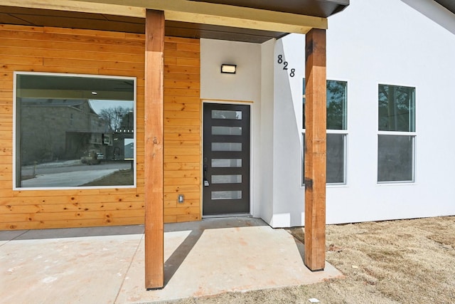 doorway to property featuring stucco siding