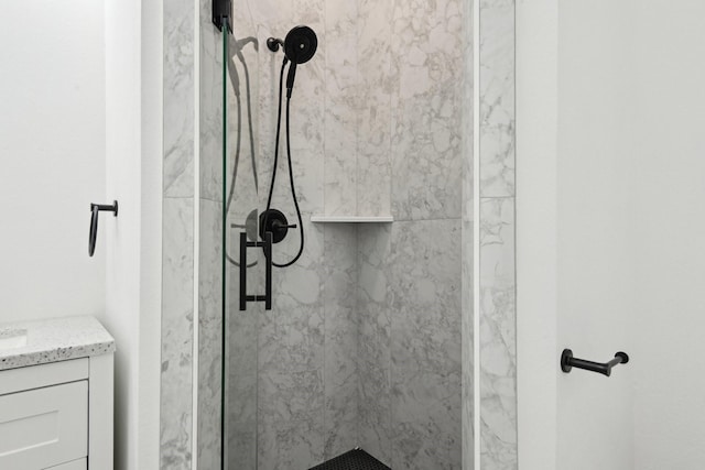 full bath with vanity and a marble finish shower